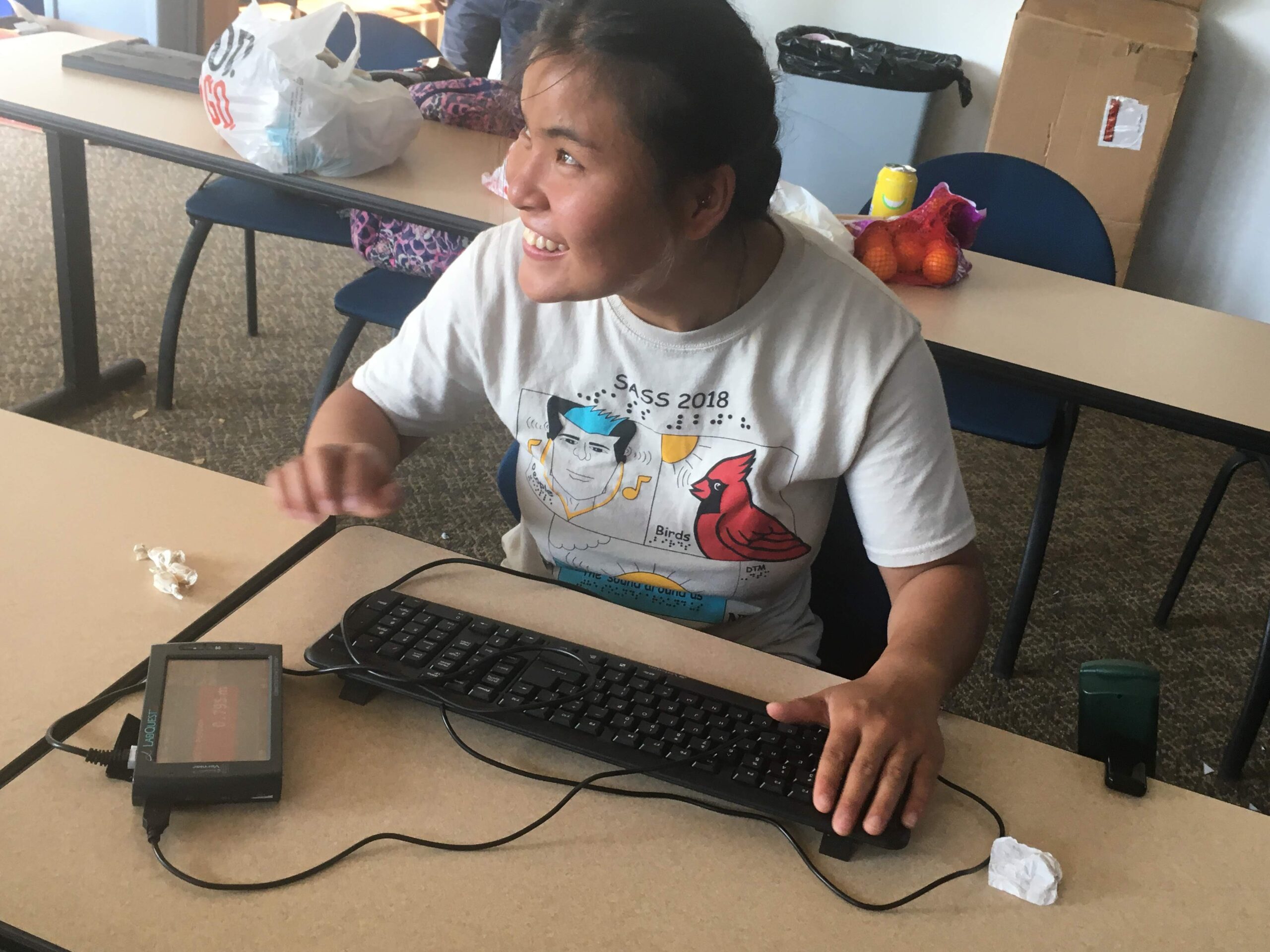 A student has a huge smile on her face while using the motion sensor with hand movement
