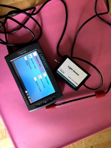 A Talking LabQuest with a light sensor on a red background
