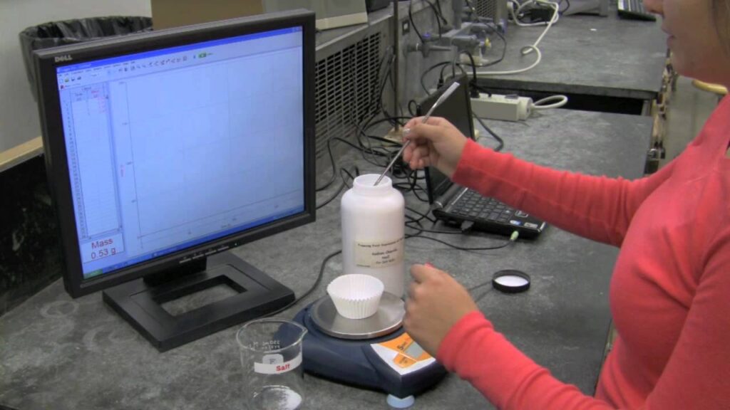 Photograph of a blind student using Sci-Voice Talking LoggerPro running on a PC computer interfaced with the Scout Pro Balance to measure the mass of a salt sample.